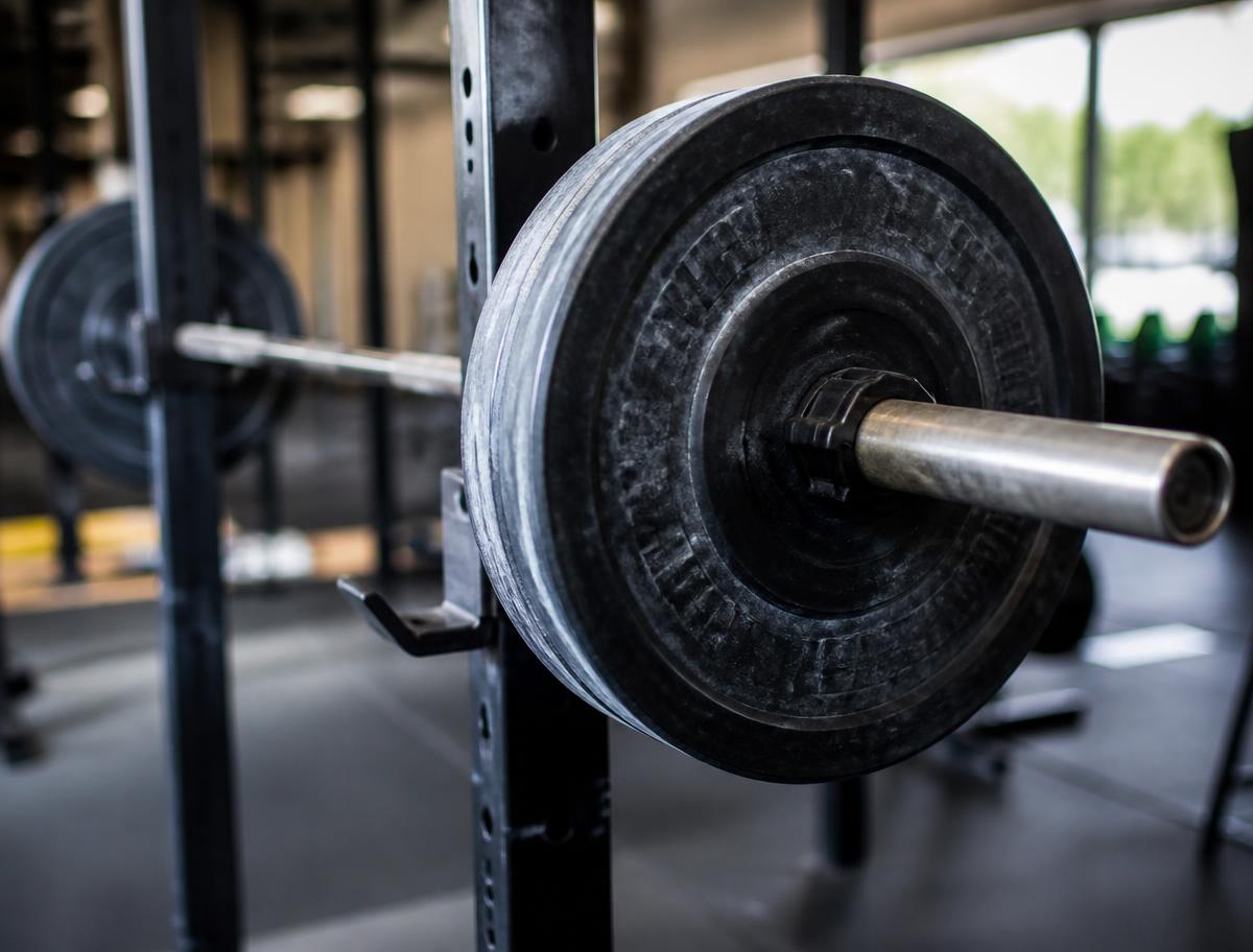 Loaded barbell resting in a squat rack inside a modern training facility
